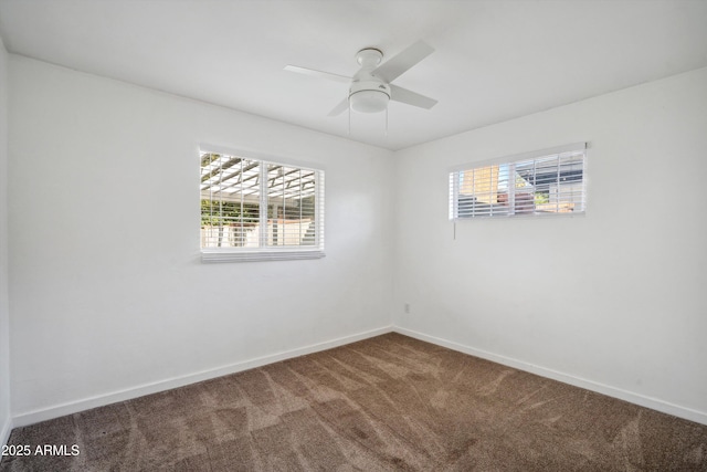 carpeted empty room with ceiling fan and baseboards