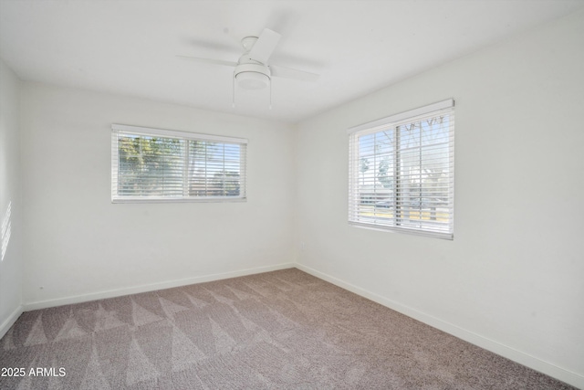 empty room featuring baseboards, a ceiling fan, and light colored carpet