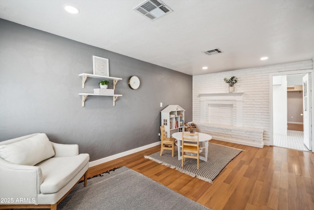 living area featuring baseboards, visible vents, wood finished floors, and recessed lighting