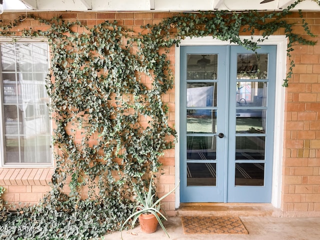 doorway to property featuring brick siding and french doors