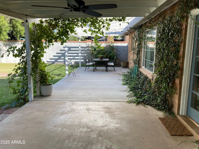 view of patio / terrace with ceiling fan, a fenced backyard, and outdoor dining space