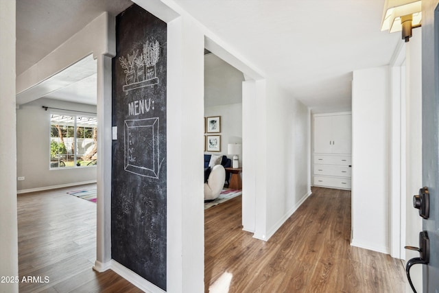 hallway with baseboards and wood finished floors