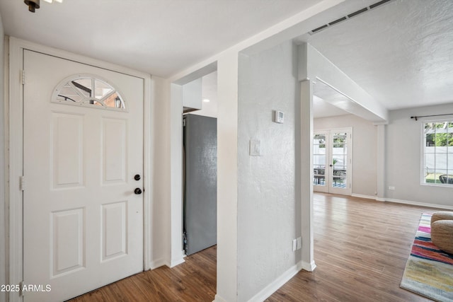 foyer entrance featuring baseboards and wood finished floors