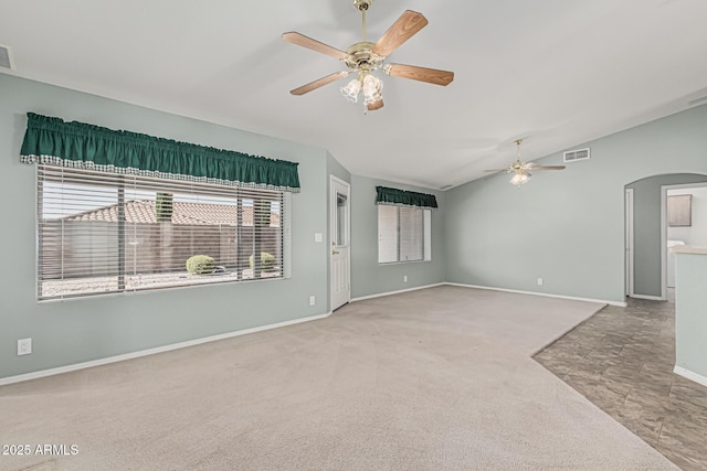 unfurnished room featuring ceiling fan, arched walkways, baseboards, lofted ceiling, and carpet flooring