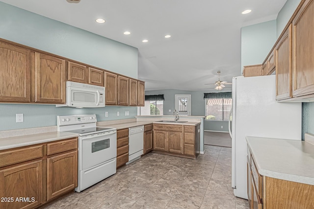 kitchen featuring a peninsula, white appliances, light countertops, brown cabinets, and a sink