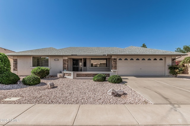 ranch-style home featuring concrete driveway, an attached garage, roof with shingles, and stucco siding