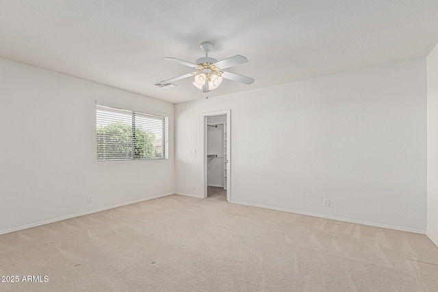 unfurnished bedroom featuring baseboards, visible vents, light carpet, and a spacious closet