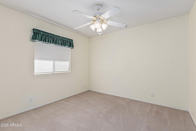 carpeted spare room with baseboards and ceiling fan