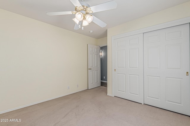 unfurnished bedroom with a ceiling fan, baseboards, light colored carpet, and a closet