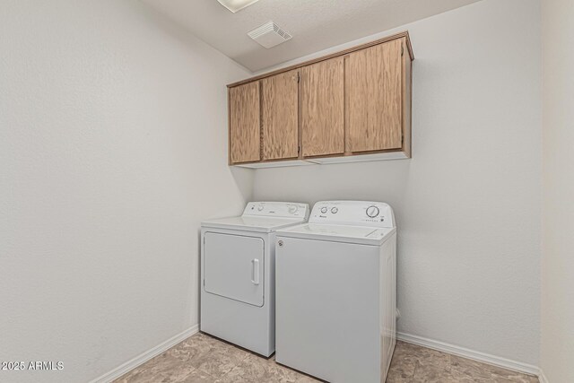 laundry area featuring separate washer and dryer, baseboards, cabinet space, and visible vents