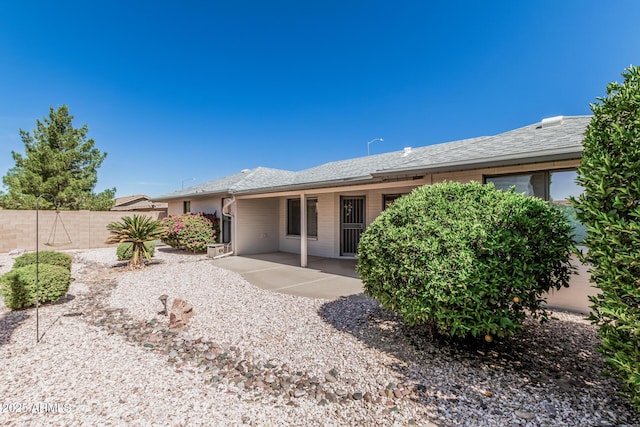 rear view of house featuring a patio and fence