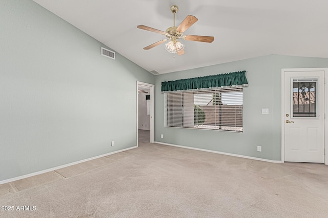 empty room featuring visible vents, lofted ceiling, baseboards, a ceiling fan, and carpet