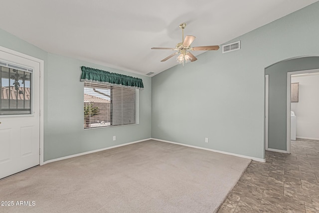 empty room with arched walkways, a ceiling fan, baseboards, lofted ceiling, and visible vents