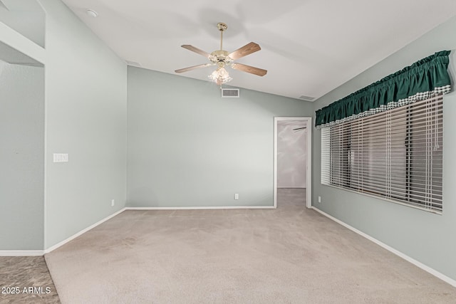 spare room featuring carpet flooring, ceiling fan, baseboards, lofted ceiling, and visible vents
