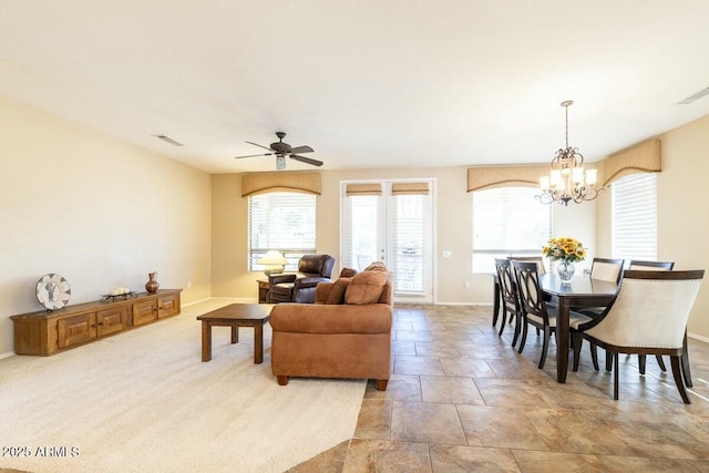 carpeted living area with visible vents, baseboards, and ceiling fan with notable chandelier