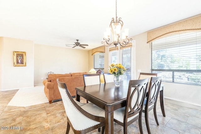 dining room with baseboards, a wealth of natural light, and ceiling fan with notable chandelier