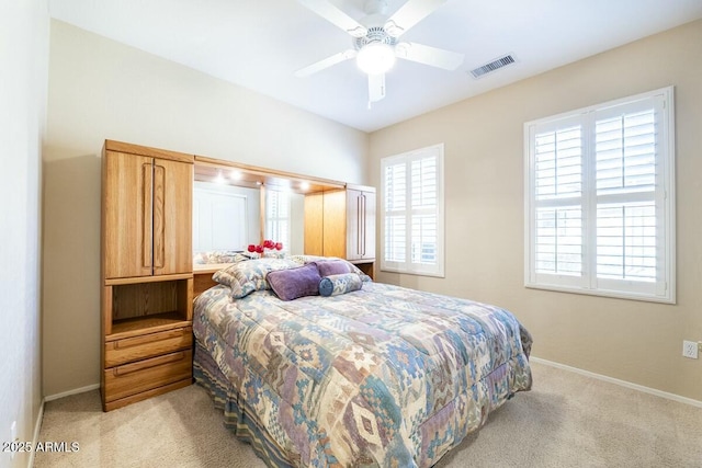 bedroom featuring light carpet, a ceiling fan, visible vents, and baseboards