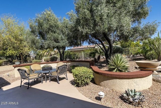 view of patio with an outdoor fire pit and fence