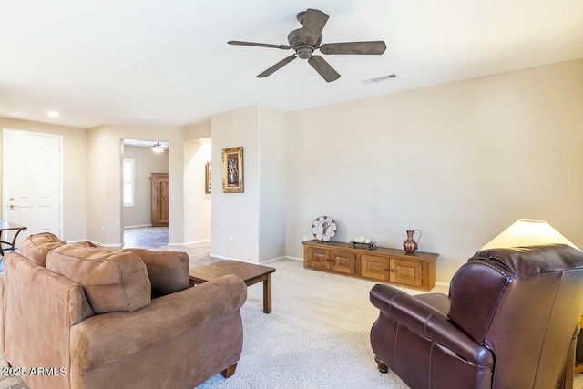 living room featuring visible vents, ceiling fan, light carpet, and baseboards