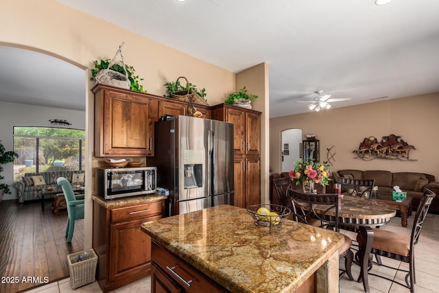 22026 N 44th Pl, Phoenix, AZ 85050 - kitchen featuring ceiling fan, light stone countertops, arched walkways, appliances with stainless steel finishes, and open floor plan