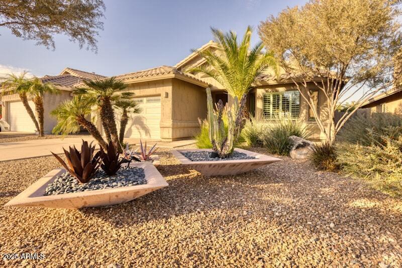 3212 E Desert Cove Ave, Phoenix, AZ 85028 - ranch-style home with an attached garage, a tiled roof, and stucco siding