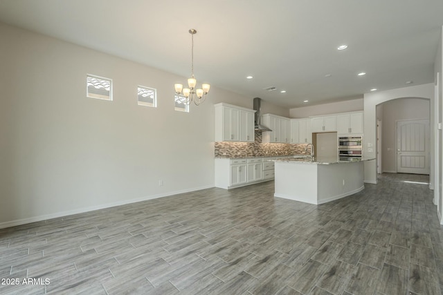 4090 E Bethena St, Gilbert, AZ 85295 - kitchen with a notable chandelier, backsplash, a sink, wall chimney exhaust hood, and open floor plan