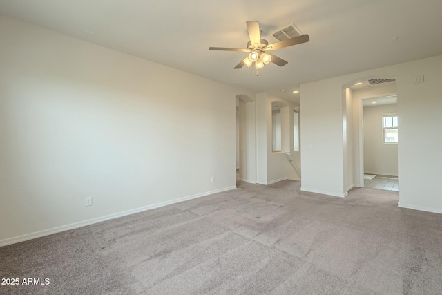 4090 E Bethena St, Gilbert, AZ 85295 - spare room with visible vents, baseboards, ceiling fan, arched walkways, and light colored carpet