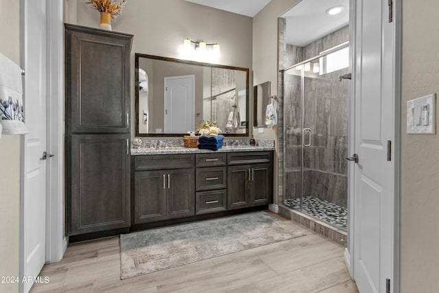 bathroom featuring vanity, a shower with shower door, and wood-type flooring