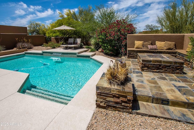 view of swimming pool featuring a patio, a fenced in pool, and an outdoor living space with a fire pit