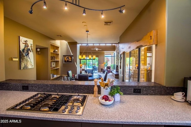kitchen featuring visible vents, stainless steel gas cooktop, built in shelves, and an inviting chandelier