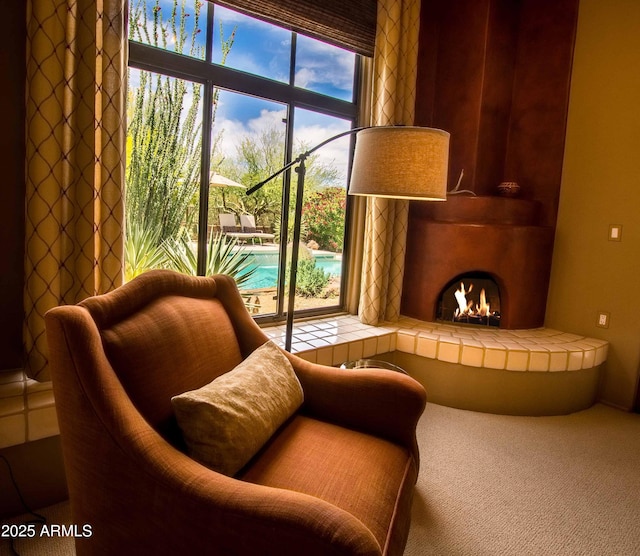 sitting room featuring carpet floors and a large fireplace