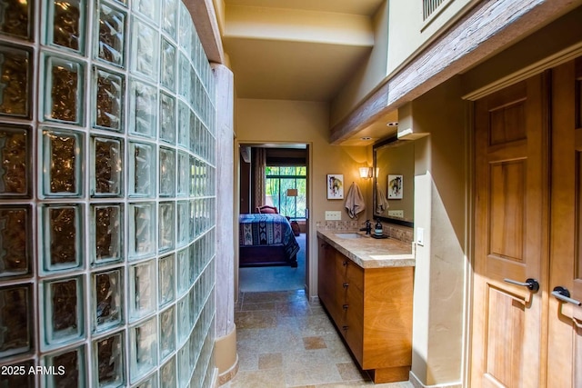ensuite bathroom with vanity, ensuite bathroom, and stone finish floor