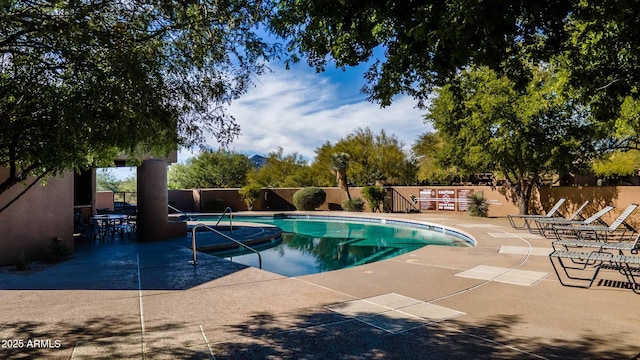 pool with a patio and fence
