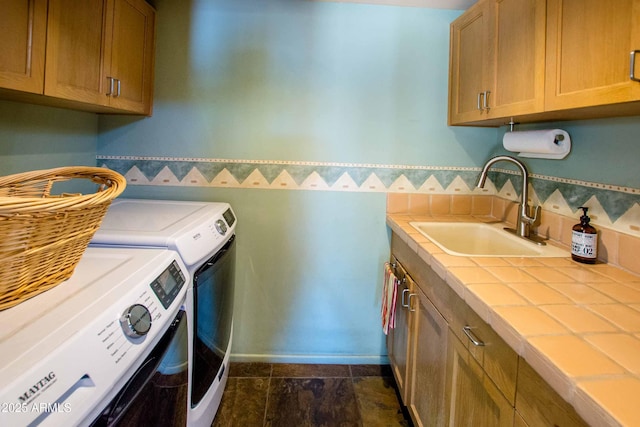 clothes washing area featuring cabinet space, independent washer and dryer, and a sink