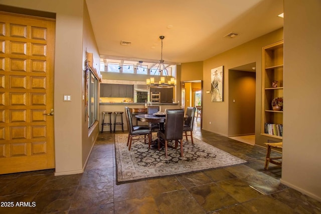dining space with baseboards, visible vents, stone tile flooring, and a chandelier