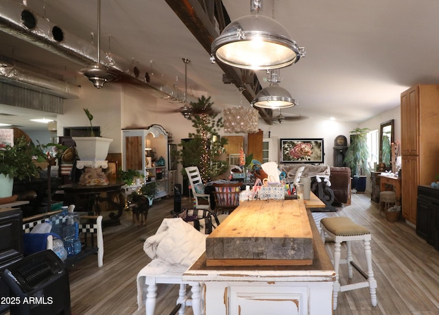 dining space featuring lofted ceiling and wood finished floors