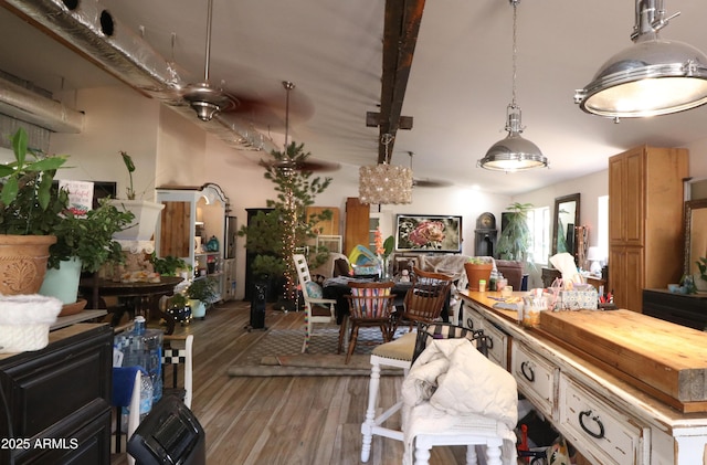 interior space featuring open floor plan, decorative light fixtures, butcher block counters, and wood finished floors