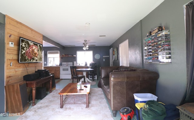 living area with visible vents and ceiling fan