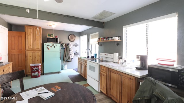 kitchen featuring white appliances, visible vents, light countertops, brown cabinets, and pendant lighting