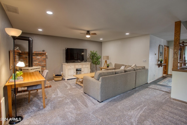 living room with a ceiling fan, carpet floors, a wood stove, visible vents, and recessed lighting