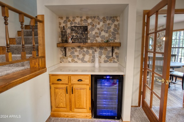 bar featuring wine cooler, french doors, and a bar