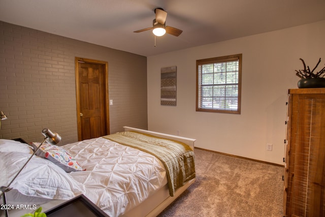 bedroom featuring a ceiling fan, carpet flooring, baseboards, and brick wall