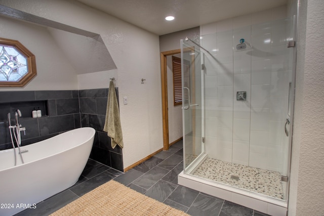 bathroom with recessed lighting, a soaking tub, a stall shower, and a textured wall