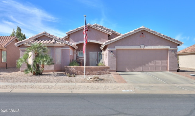 view of front of property featuring a garage, concrete driveway, a tile roof, and stucco siding