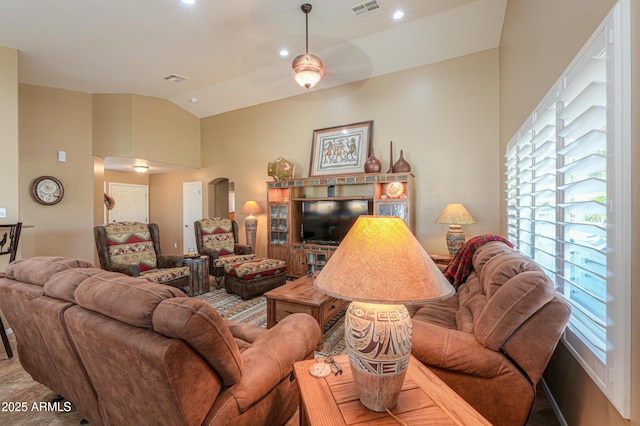 living room featuring arched walkways, visible vents, and lofted ceiling