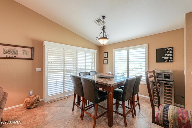 dining room with lofted ceiling, light tile patterned floors, baseboards, and visible vents