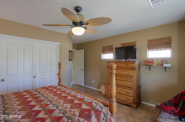 bedroom featuring multiple windows, a closet, visible vents, and baseboards