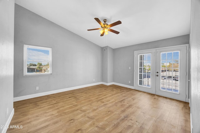 empty room featuring baseboards, french doors, light wood-style flooring, lofted ceiling, and ceiling fan