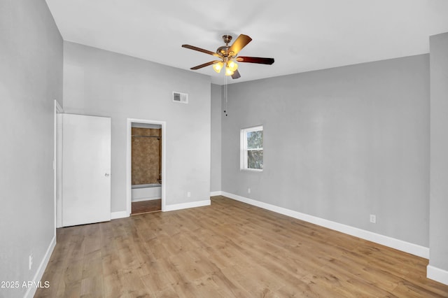 unfurnished bedroom with wood finished floors, baseboards, and visible vents