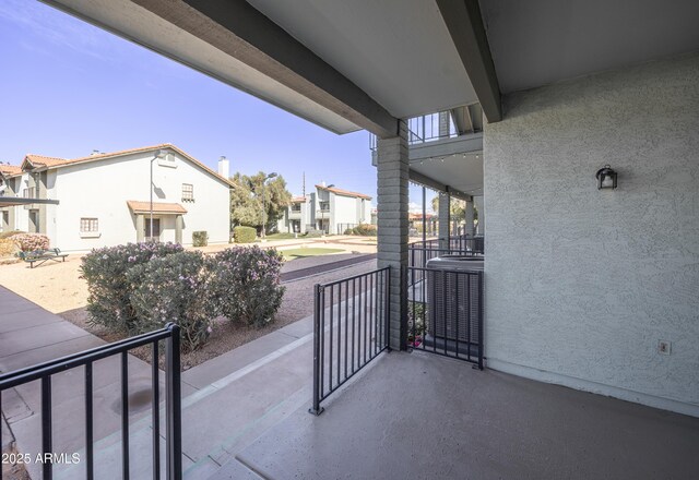 balcony with a residential view, central AC, and covered porch